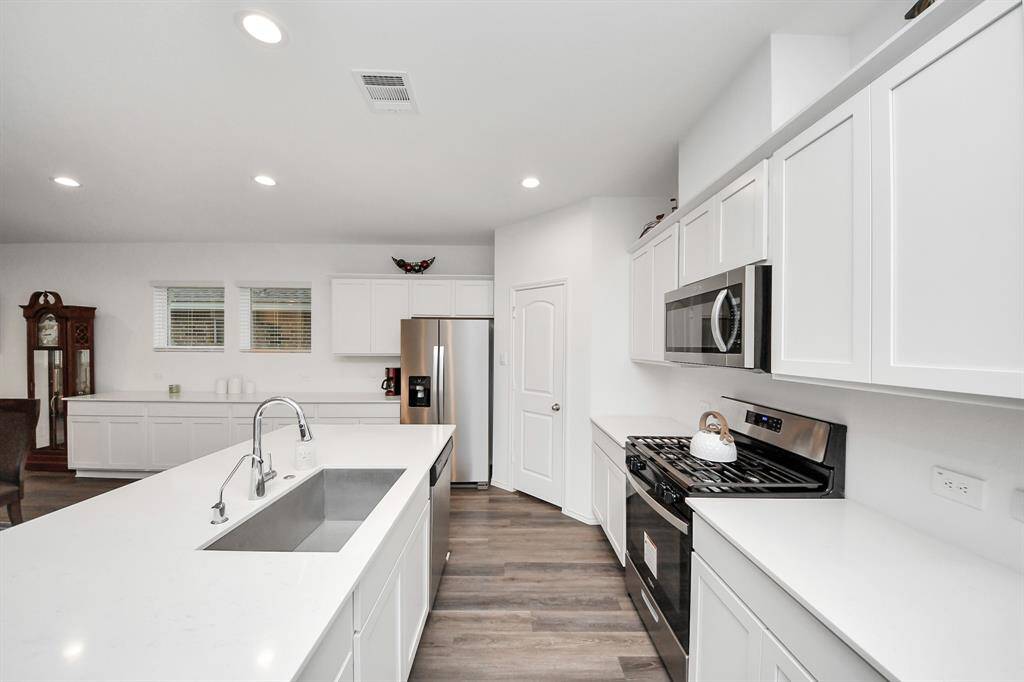 Elegant quartz countertops paired with sleek white cabinets.