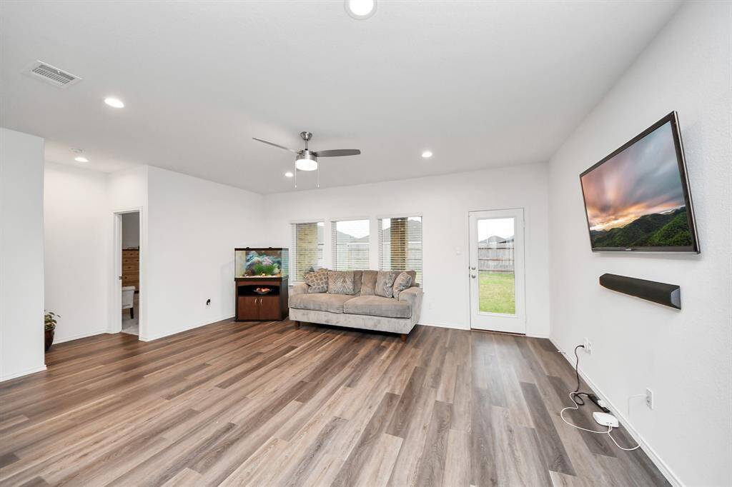 Spacious and inviting family room with modern flooring, ample natural light, and seamless access to the backyard—perfect for relaxation and entertaining.