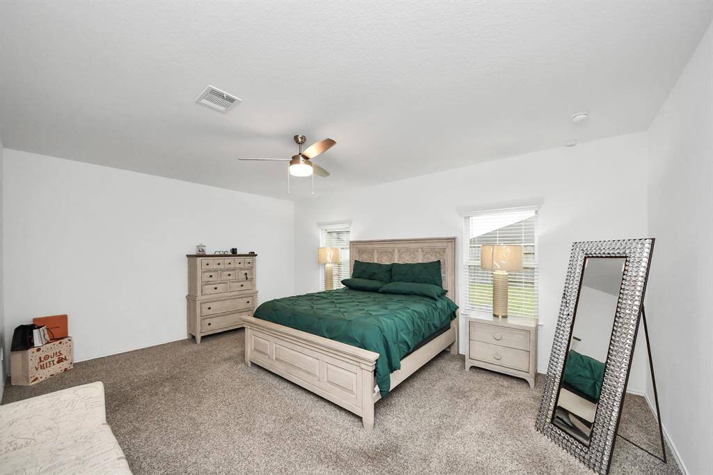 Expansive primary bedroom with ample natural light and cozy ambiance.