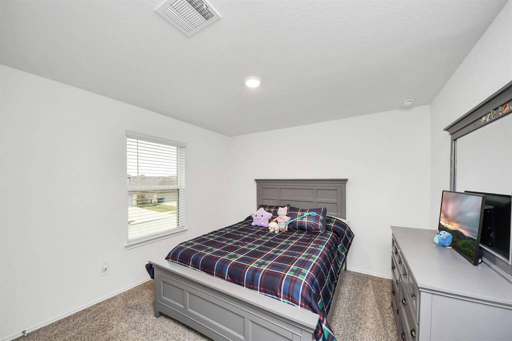 Cozy and bright third bedroom with ample natural light, ideal for a guest room or home office.