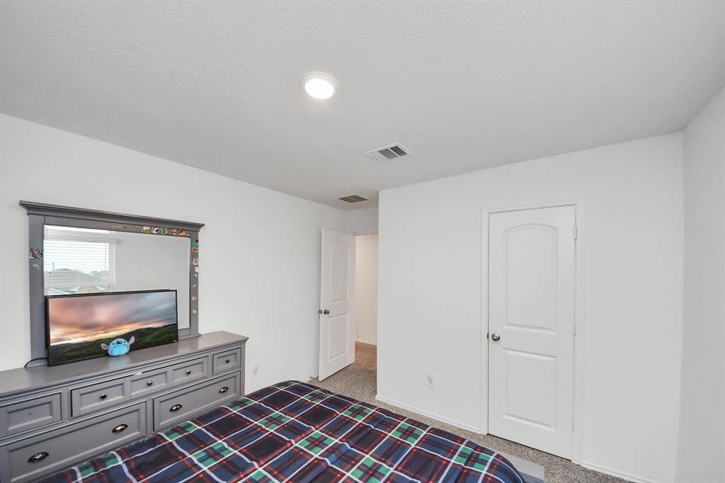 Cozy third bedroom with ample natural light and a spacious closet, perfect for guests or a home office.