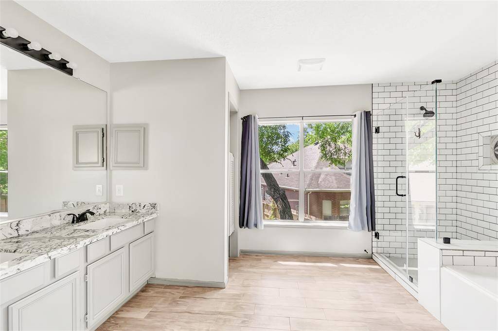 Ensuite with double vanities, separate shower , and soaker tub