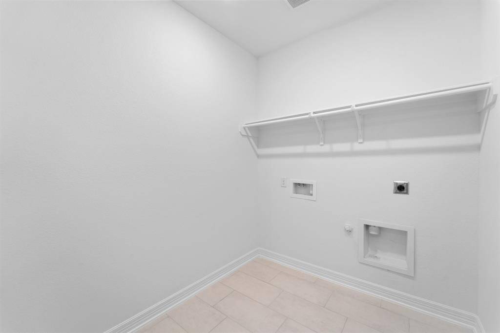 The laundry room layout is carefully planned for optimal workflow with designated areas for washing, drying, and storing.