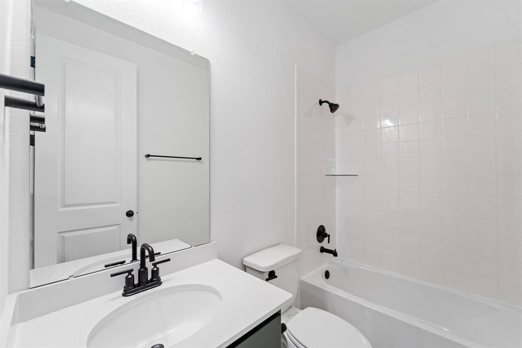 The secondary bath features tile flooring, white cabinetry and light countertops and a shower/tub combo. Perfect for accommodating any visiting family and friends.