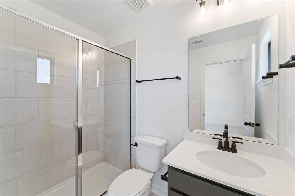 The secondary bath features tile flooring, white cabinetry and light countertops and a shower/tub combo. Perfect for accommodating any visiting family and friends.