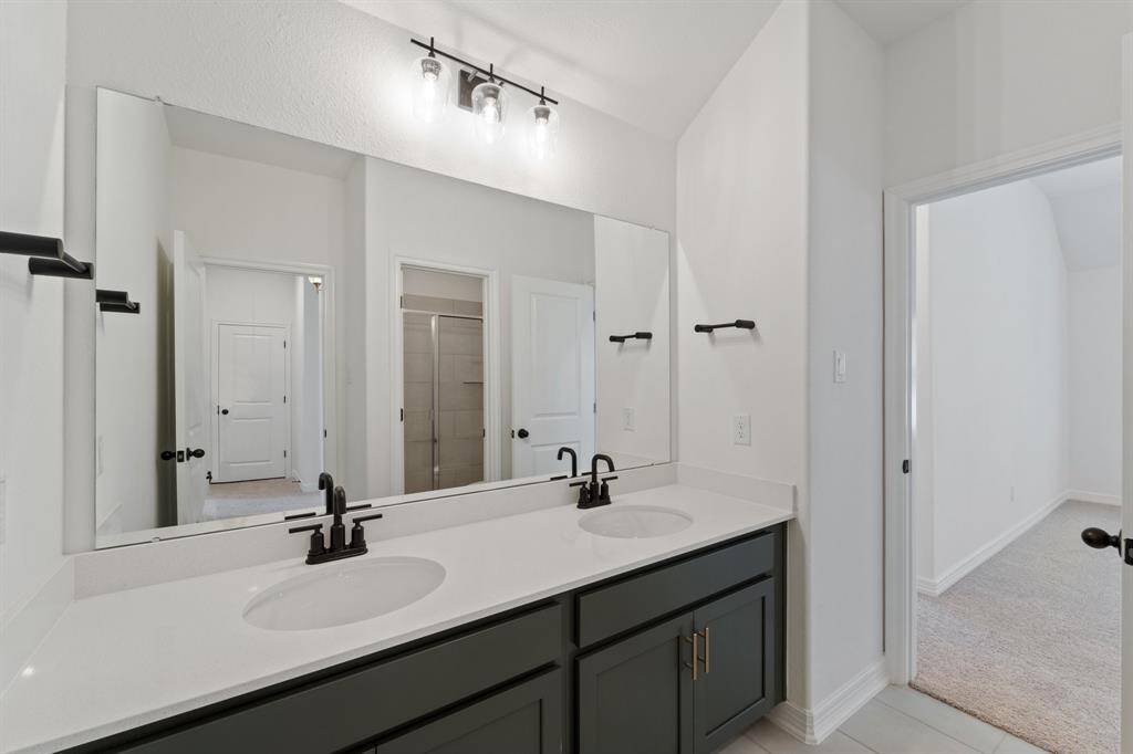 The secondary bath features tile flooring, white cabinetry and light countertops and a shower/tub combo. Perfect for accommodating any visiting family and friends.