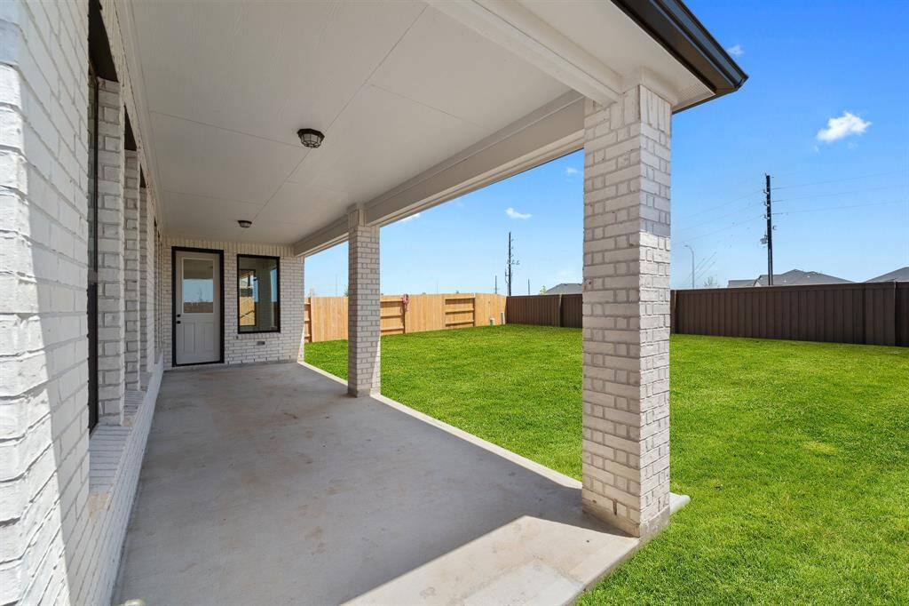 The covered patio is generously sized, providing ample space for various outdoor activities.