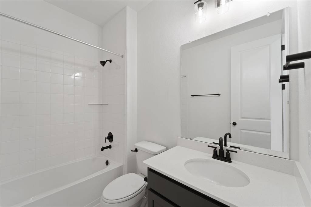 The secondary bath features tile flooring, white cabinetry and light countertops and a shower/tub combo. Perfect for accommodating any visiting family and friends.