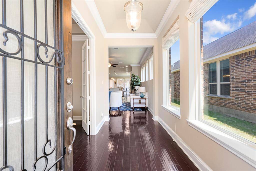Welcome home! A private foyer is enhanced by large windows and charming light fixture!