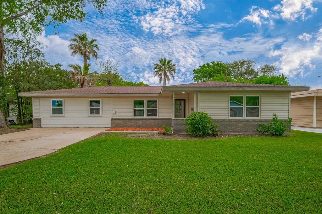 A lush, expansive lawn sets the stage for this charming home, where clean architectural lines and a spacious driveway offer an inviting first impression. The covered front porch adds a welcoming touch.