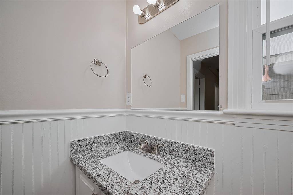 Conveniently located, this half bath includes a sleek vanity with lower cabinetry and stylish lighting above the mirror—ideal for guests and daily routines alike.
