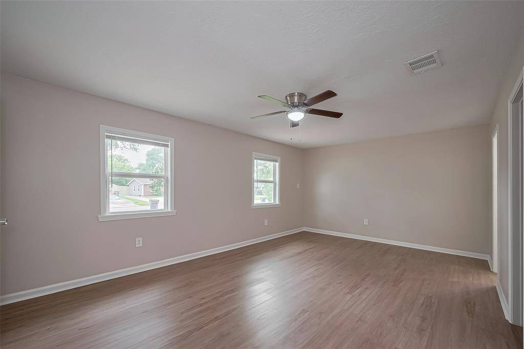 The spacious primary suite features multiple windows that fill the room with soft light. With ample room to accommodate larger furnishings, this soothing retreat also connects to an en suite bath and a full-entry closet.