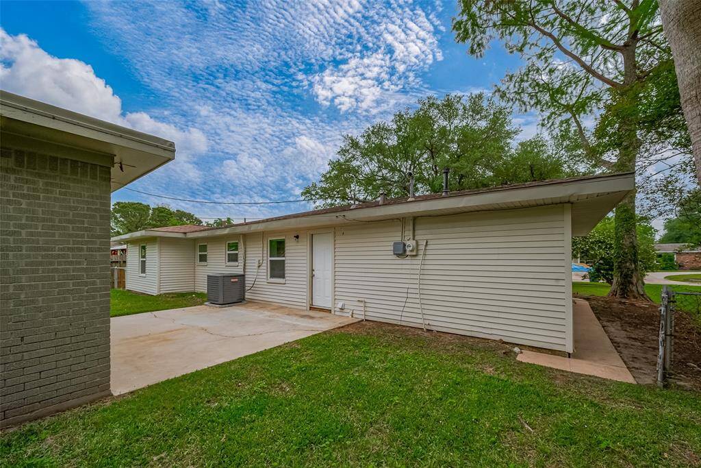An open patio bridges the home to a detached, bricked bonus room—ideal for storage, a studio, or creative projects. The patio itself provides a flexible space for outdoor lounging or entertaining under the open sky.