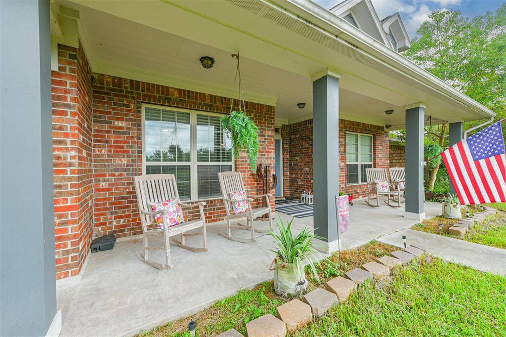 This is a welcoming brick home featuring a covered front porch with space for seating and presenting a classic and inviting atmosphere.