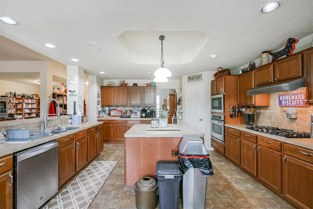 Spacious kitchen with ample cabinetry, modern appliances, an oversized island, and recessed lighting.