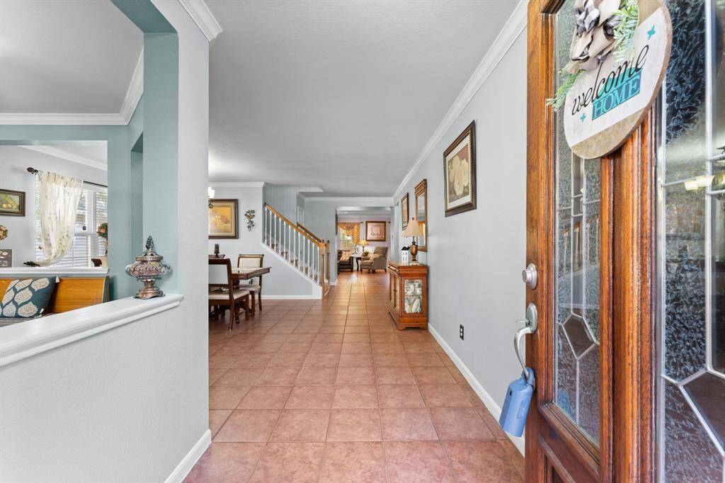 Spacious entrance of the home featuring a long hallway with tile flooring.