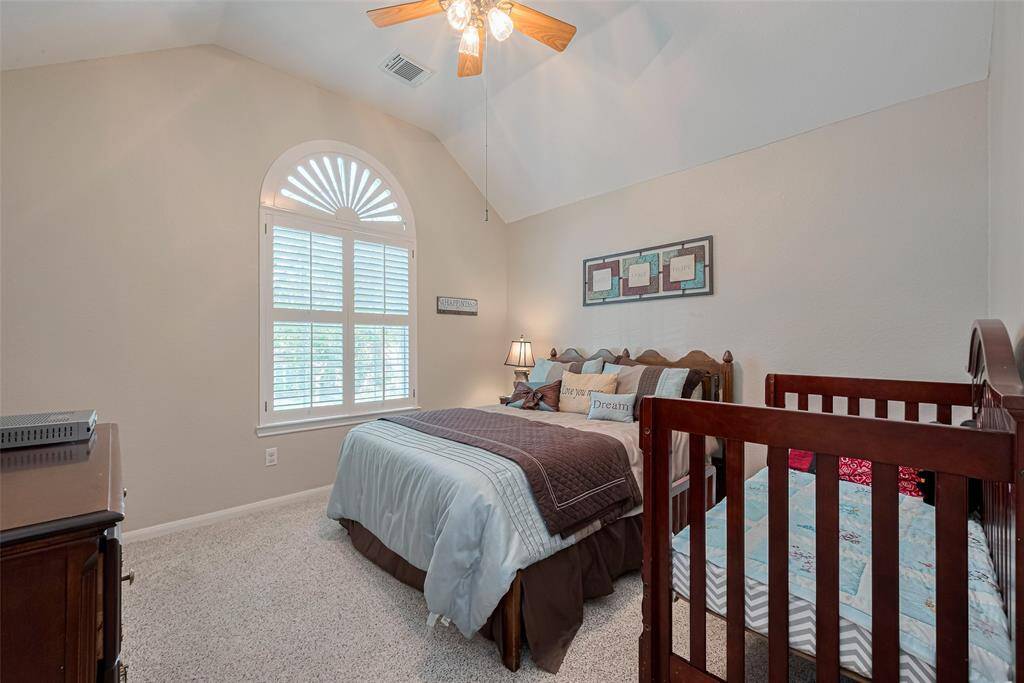 Another spacious secondary bedroom with Plantation shutters and ceiling fan