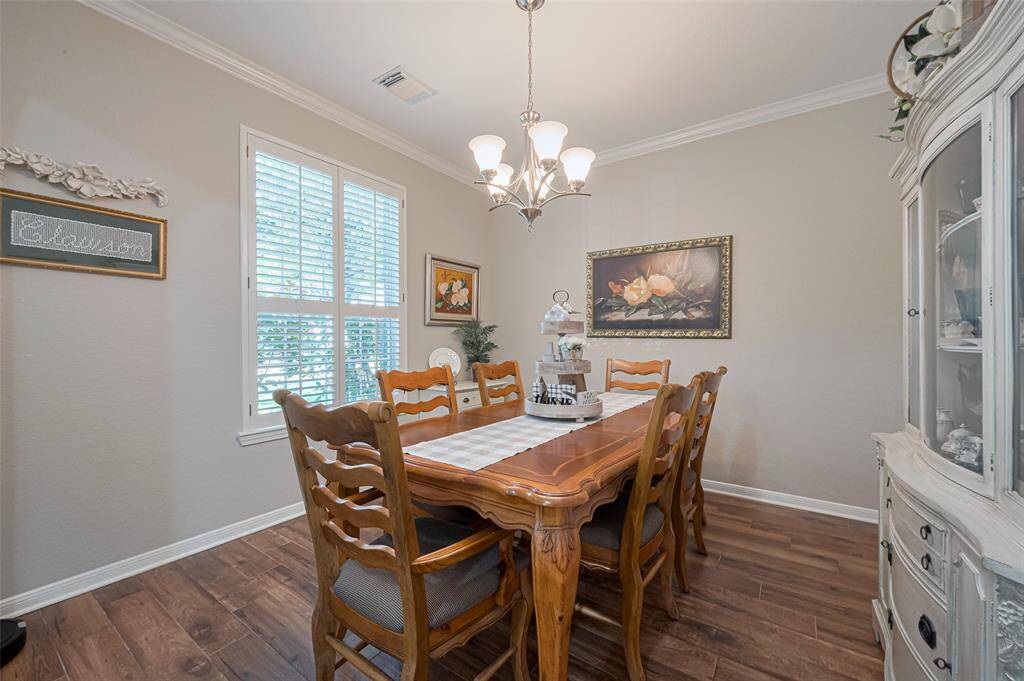 Formal dining room with crown molding and traditional Plantation shutters as well.