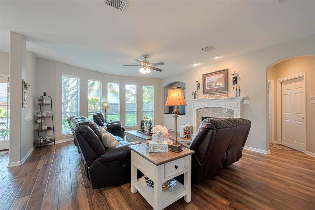 Family room with cozy fireplace is open to the granite kitchen and breakfast room - love the wall of windows with views of the large backyard!