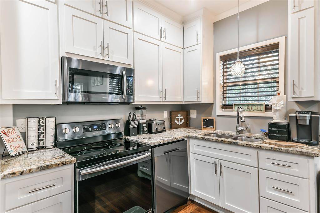 Granite countertops, a stainless steel built-in microwave, and an undermount sink complement the solid surface oven and stove..