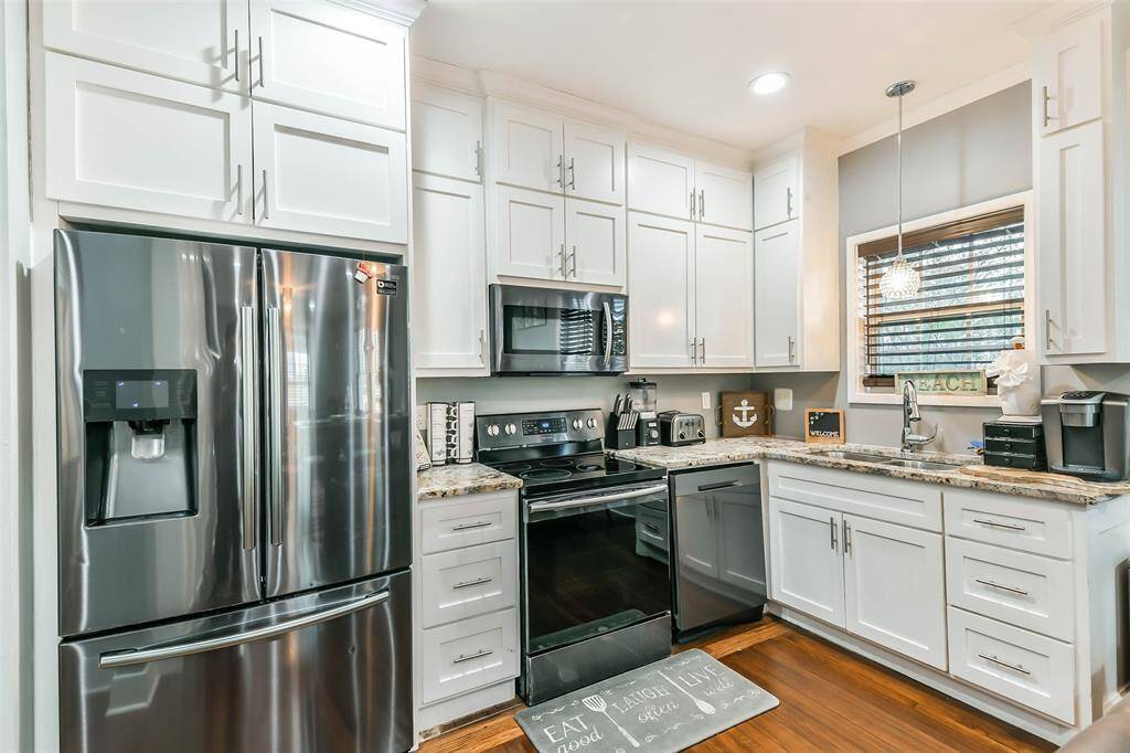 Refrigerator crafted from stainless steel, featuring a convenient drink dispenser.