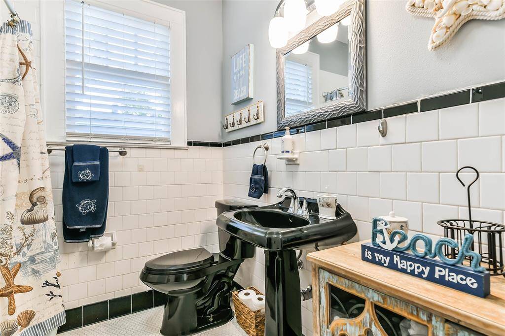 The hall bathroom features a pedestal sink, an upgraded vanity, and tiled walls with a tiled tub/shower enclosure.
