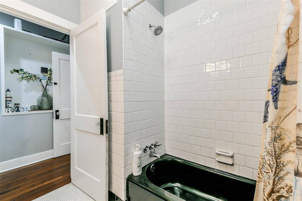 Hall bathroom featuring a tiled, enclosed tub and shower.