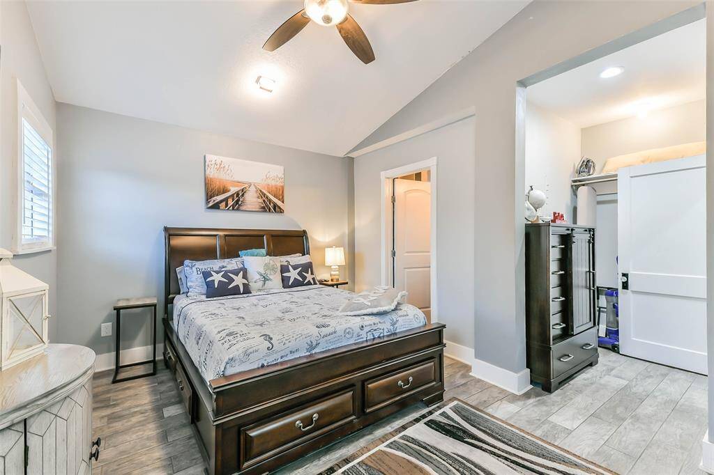 The primary bedroom, located at the rear of the home, features wood-look ceramic tile flooring and offers access to the en-suite bathroom.
