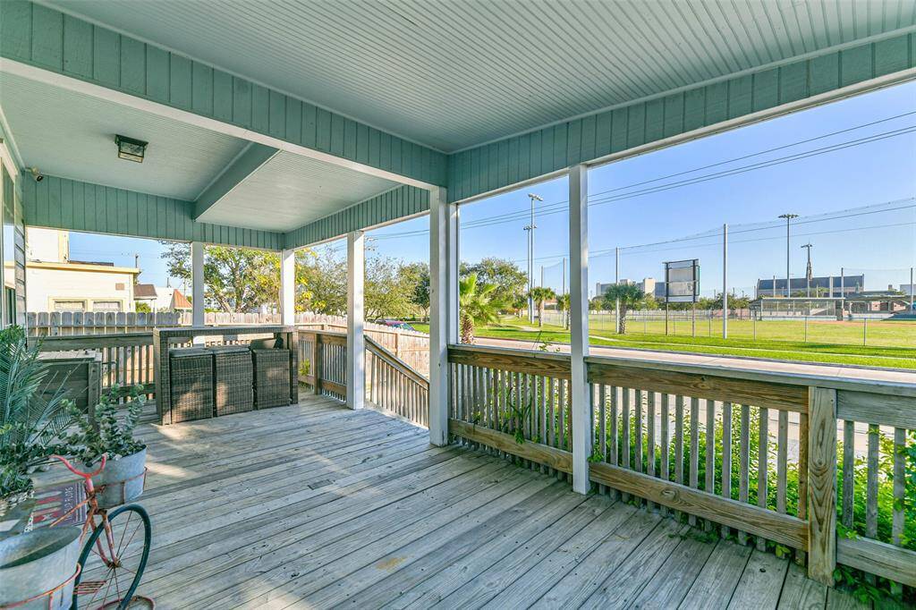 Spacious front porch equipped with stacked chairs for extra seating.