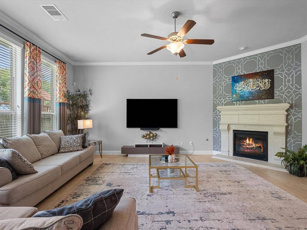 This spacious living room features large windows with beautiful water views, cozy fireplace and ceiling fans offer a warm and inviting atmosphere.