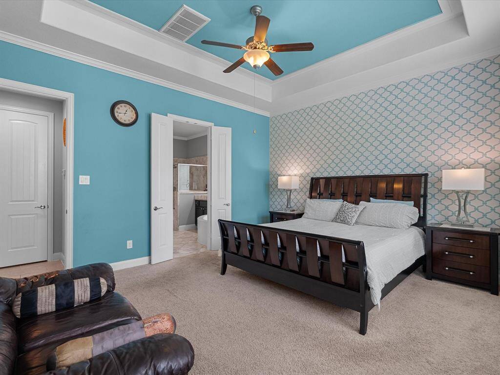 The primary bedroom is large with sitting area, an enjoining primary bath, tray ceiling and large windows, allowing for lots of natural light.