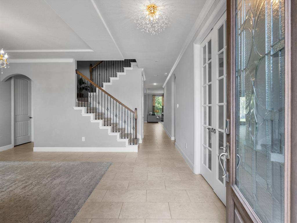 This spacious two-story home features a charming stone and brick facade, a well-maintained front yard with landscaped garden beds, and a two-car garage. Located in a serene neighborhood, it offers a welcoming driveway and abundant natural light.
