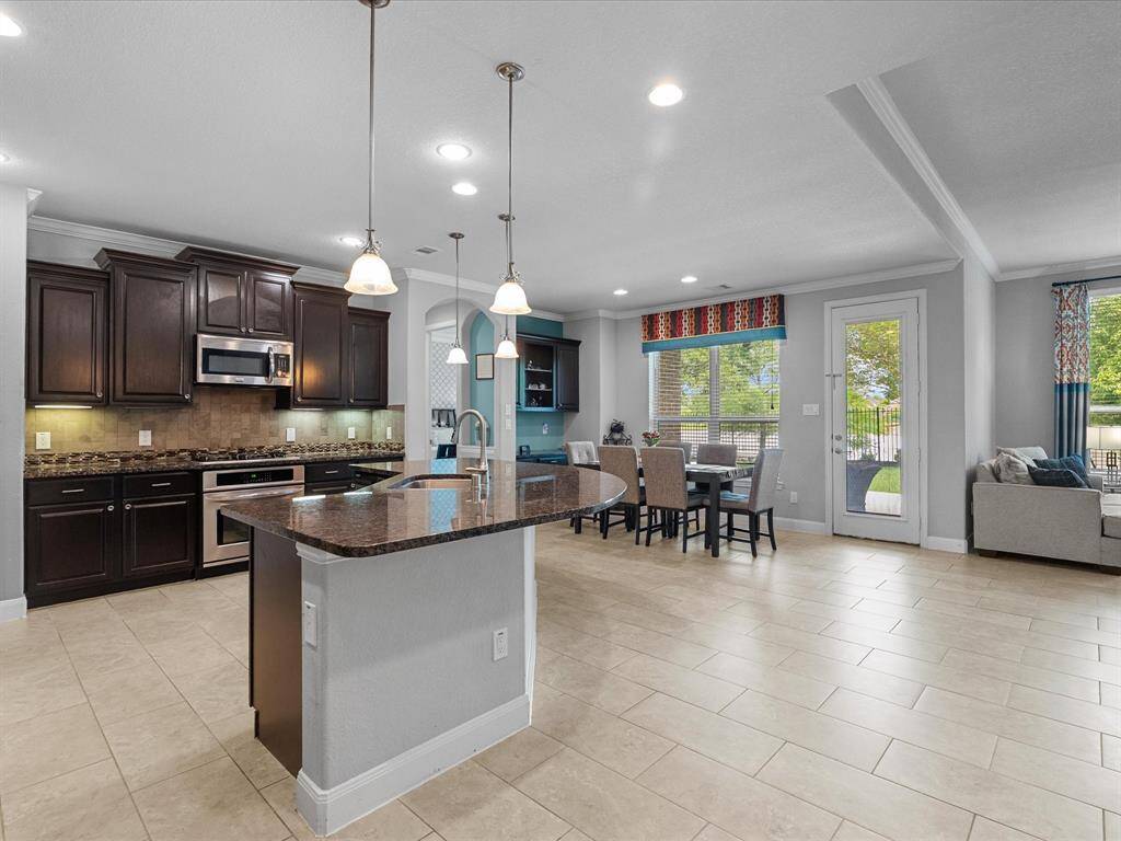 This inviting entryway features a stylish glass front door, elegant chandelier lighting, and a neutral color palette. The tile flooring complements the modern decor, while large windows allow for natural lighting.
