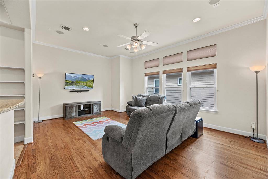 This stylish living room boasts a wonderful atmosphere, filled with natural light streaming in from a wall of windows.