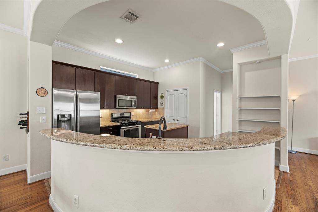 The sprawling island with breakfast bar seating serves as a versatile centerpiece, providing additional workspace, storage, and seating for casual dining or entertaining.