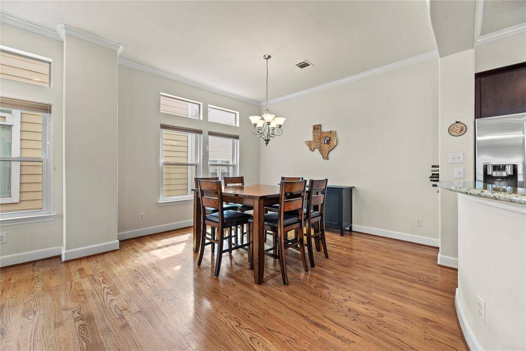 The combination of beautiful ceiling lines and wood flooring sets a stunning backdrop for the dining space, adding warmth, texture, and architectural interest.