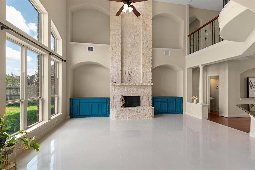 FAMILY ROOM WITH AN ELEGANT FIREPLACE  AND HIGH CEILING..