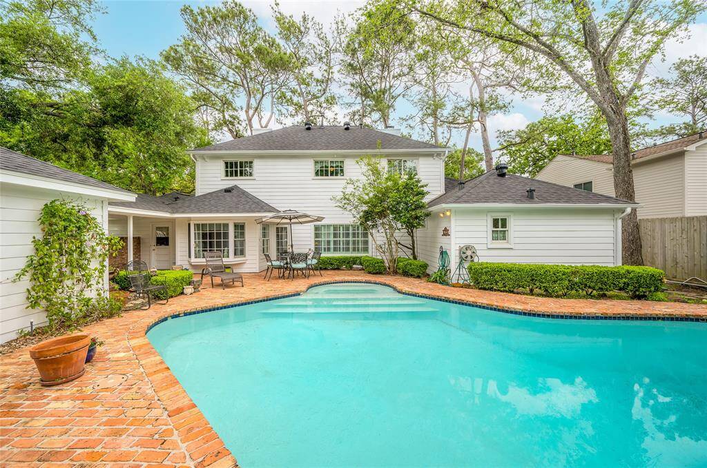 This charming two-story home features a classic colonial design with white brick, black shutters, and a back yard retreat. It definitely has charm overload.