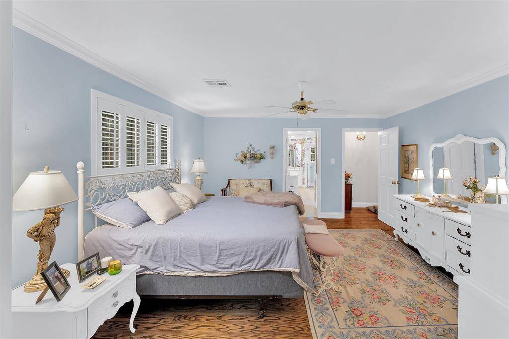 This view of the primary bedroom shows the entry to the bedroom from the den on the right and the primary bathroom in the other doorway.