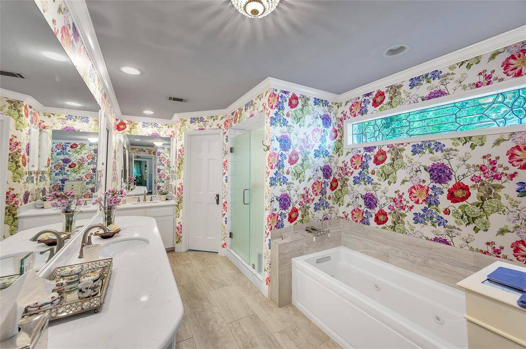 The primary bathroom has all the features one would expect in a grand home, as this one is.  Note the double sinks, jetted tub, separate shower and water closet.