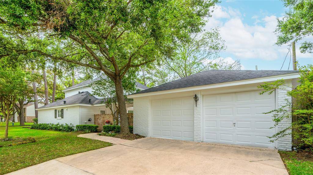 Two-car garage with double-wide driveway and side view of the house siding to Kellywood.