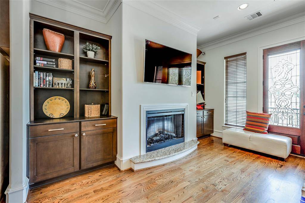 Beautiful Living Room with gas fire, built-ins, hard wood floors, high ceiling & lead glass patio doors out to patio