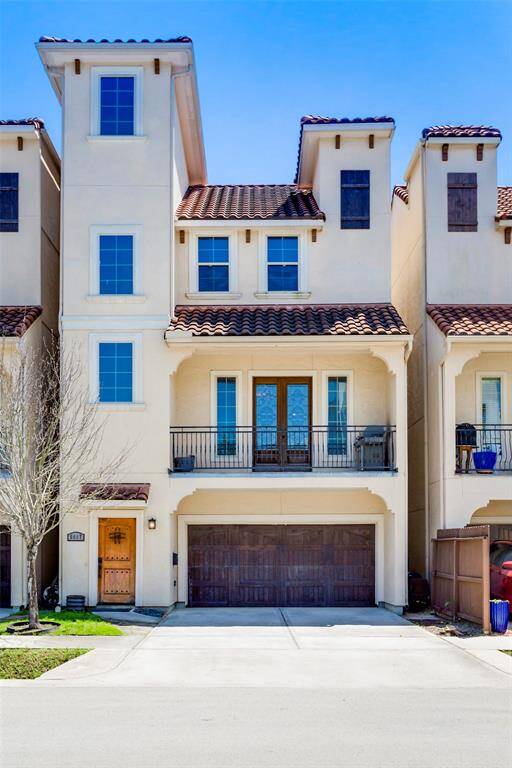 Beautiful stucco home with tile roof with balcony out from the first floor living room.