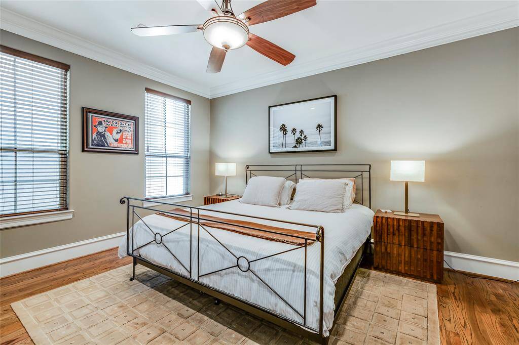 Large Primary bedroom with hardwood floors, ceiling fan, 2 inch blinds