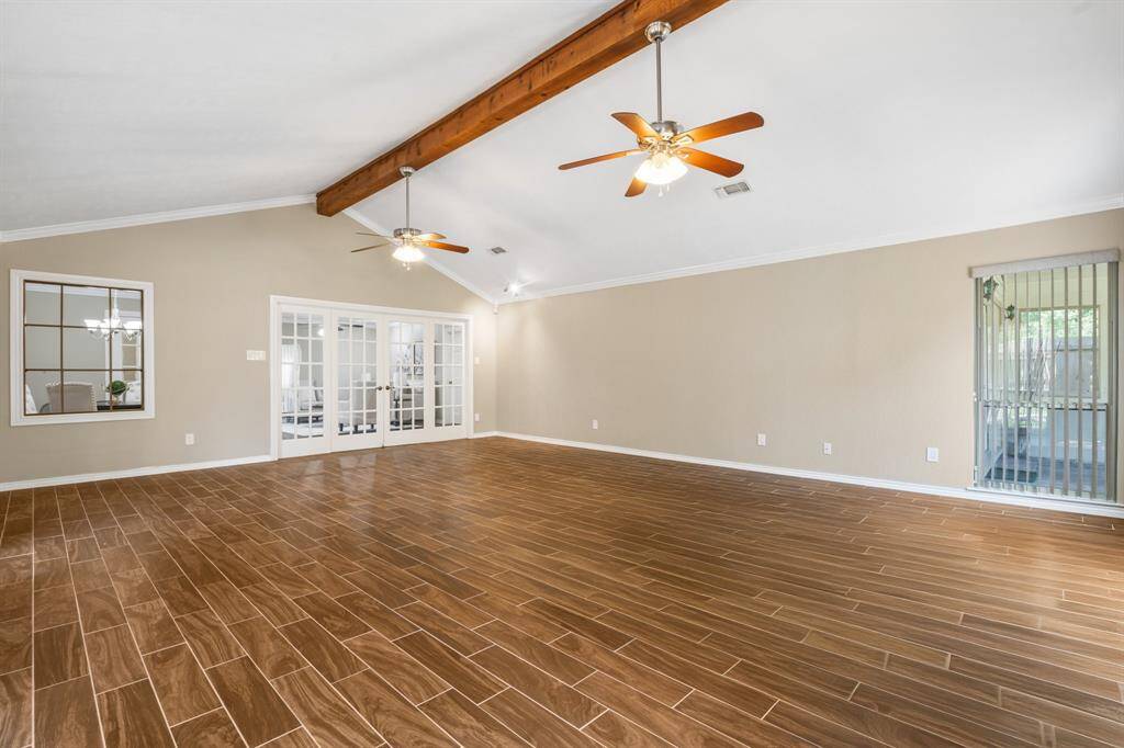 Another view of the game room with wood look tile.  Wall of french doors lead you back into the family room area.