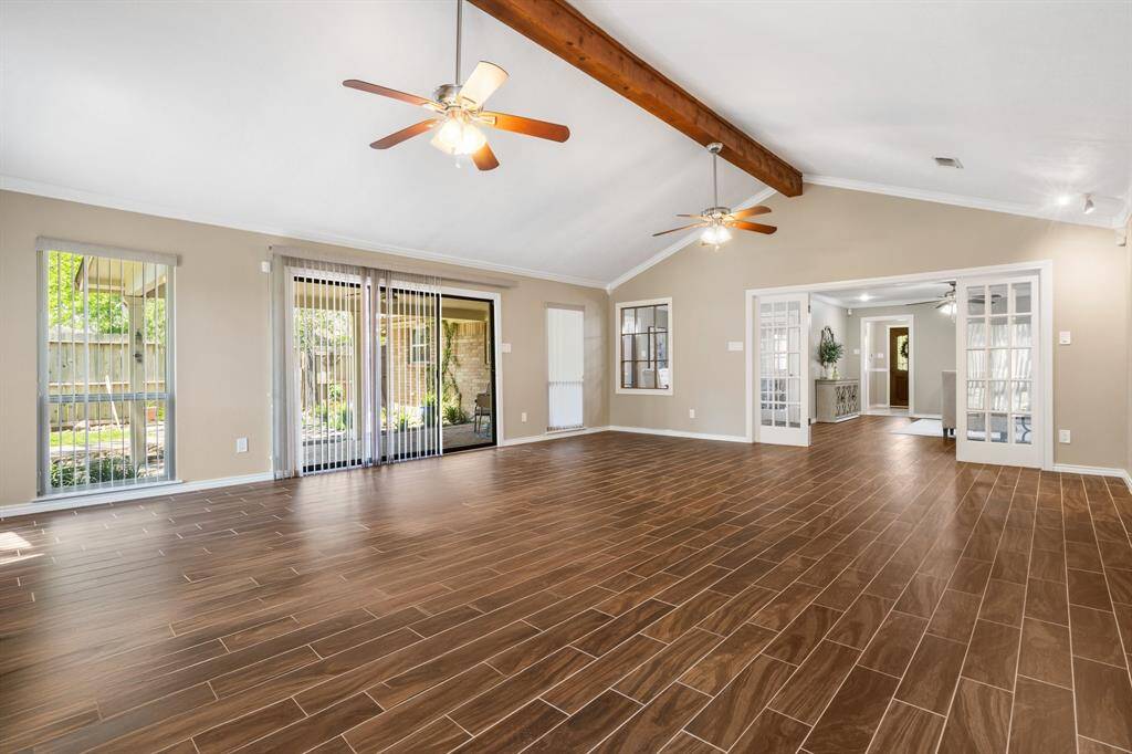 Sliding glass doors offer access to the covered back porch.  The space provides plenty of room for a pool table, and another seating area.  It's huge!