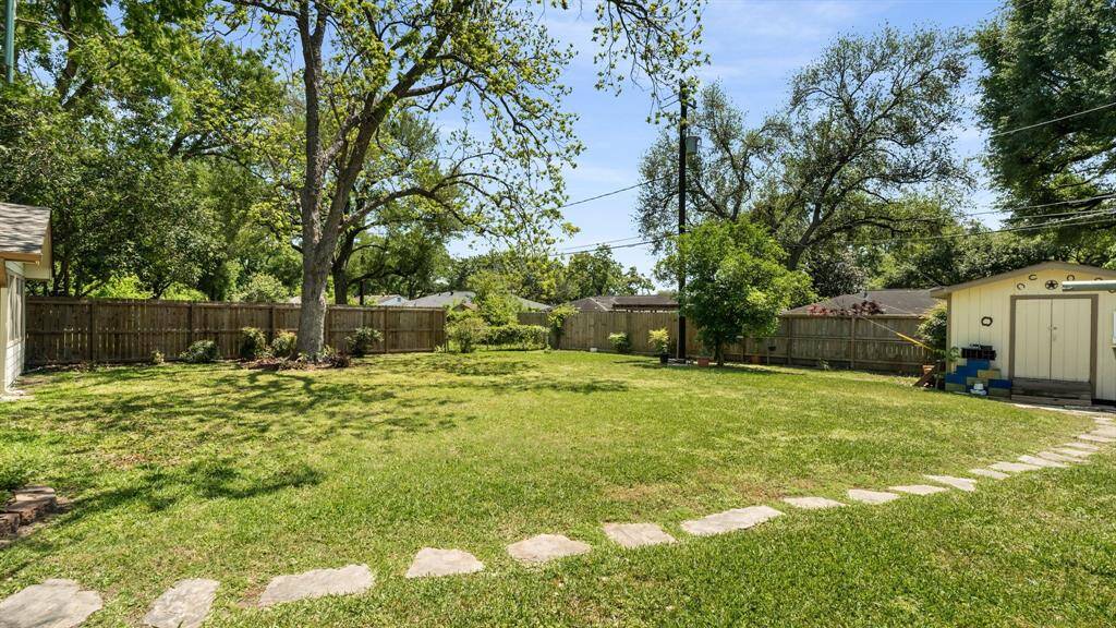 Spacious backyard with a storage shed for storing all of your lawn and gardening equipment.