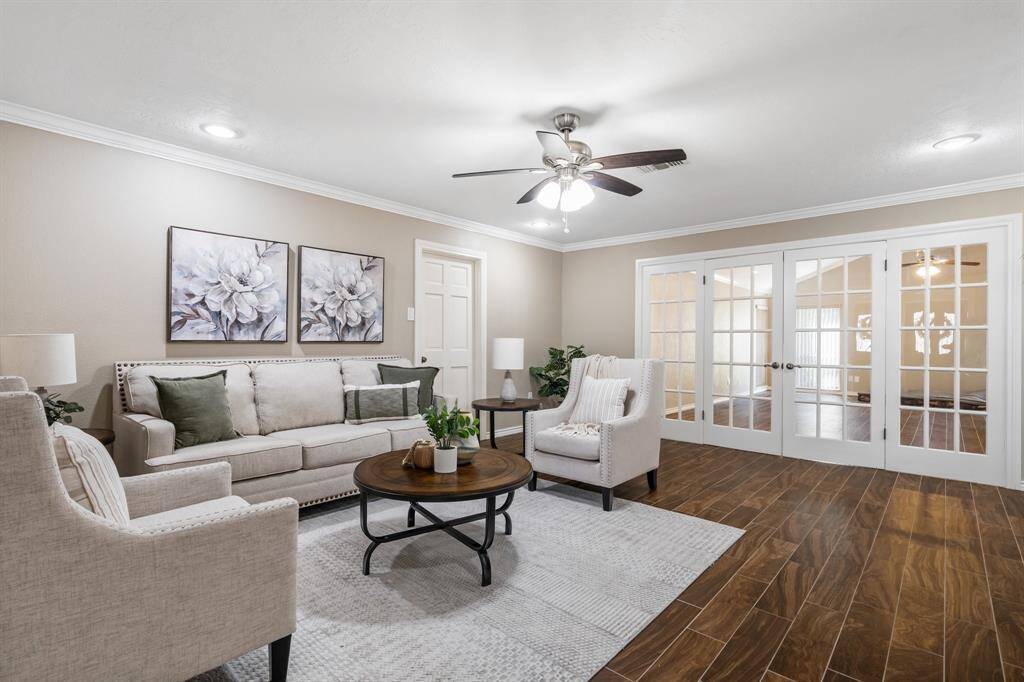 The cozy family room is located off the kitchen and breakfast area. Crown molding and the wall of french doors lead into the enormous game room.  The wood look tile flooring is both durable and beautiful.
