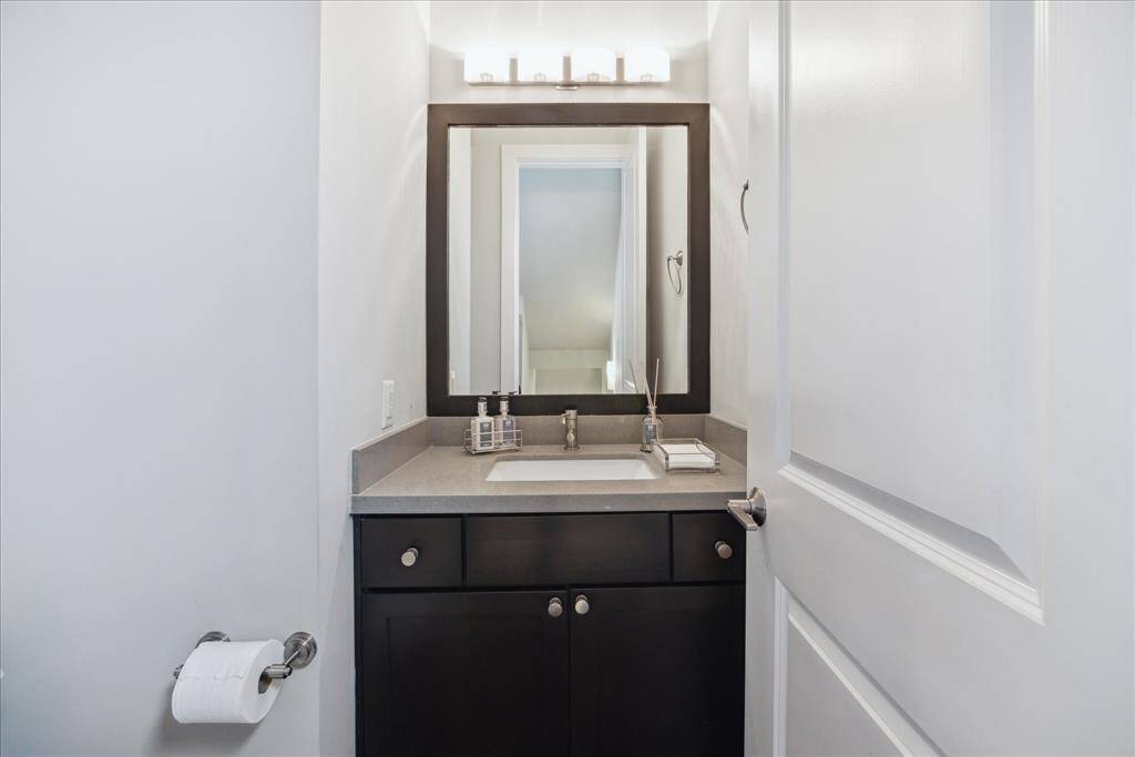 A powder room with contemporary finishes adds convenience to the second floor.