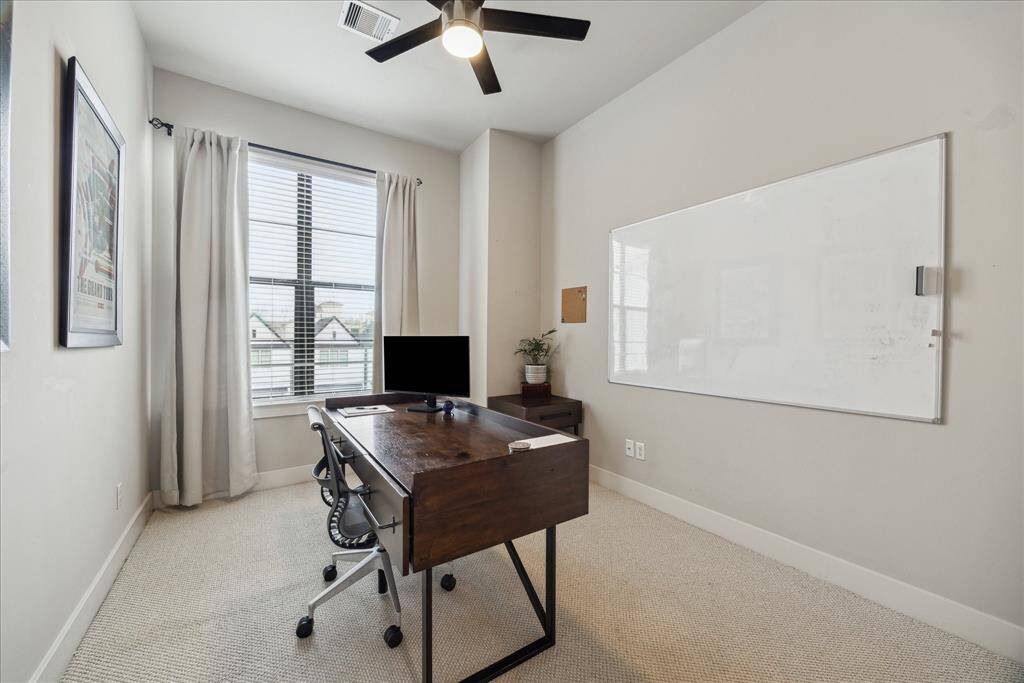 This top-floor secondary suite offers luxe carpeting, a walk-in closet, a ceiling fan and an en suite bathroom.